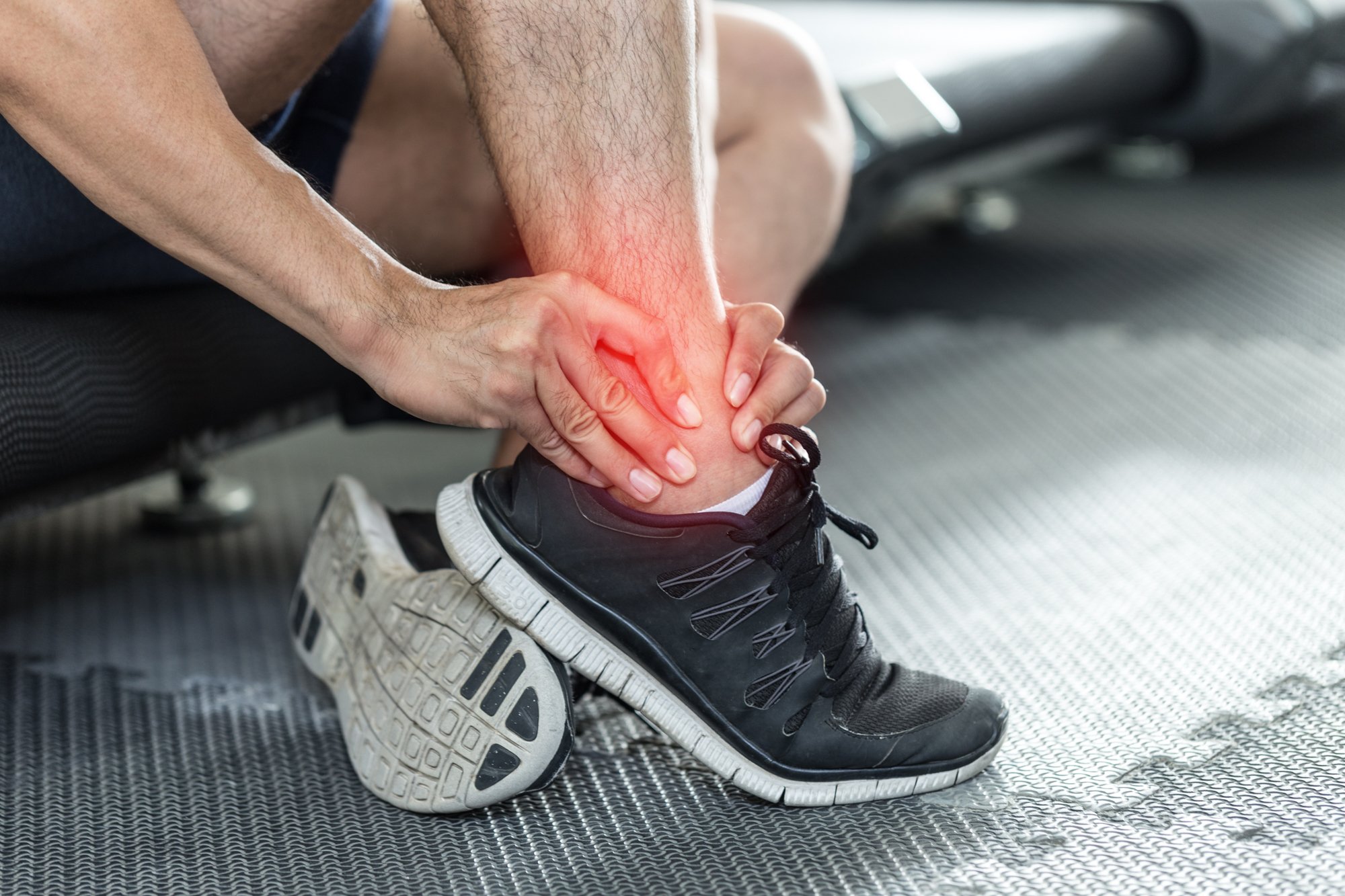 Active Man in Gym Massaging Ankle Pain