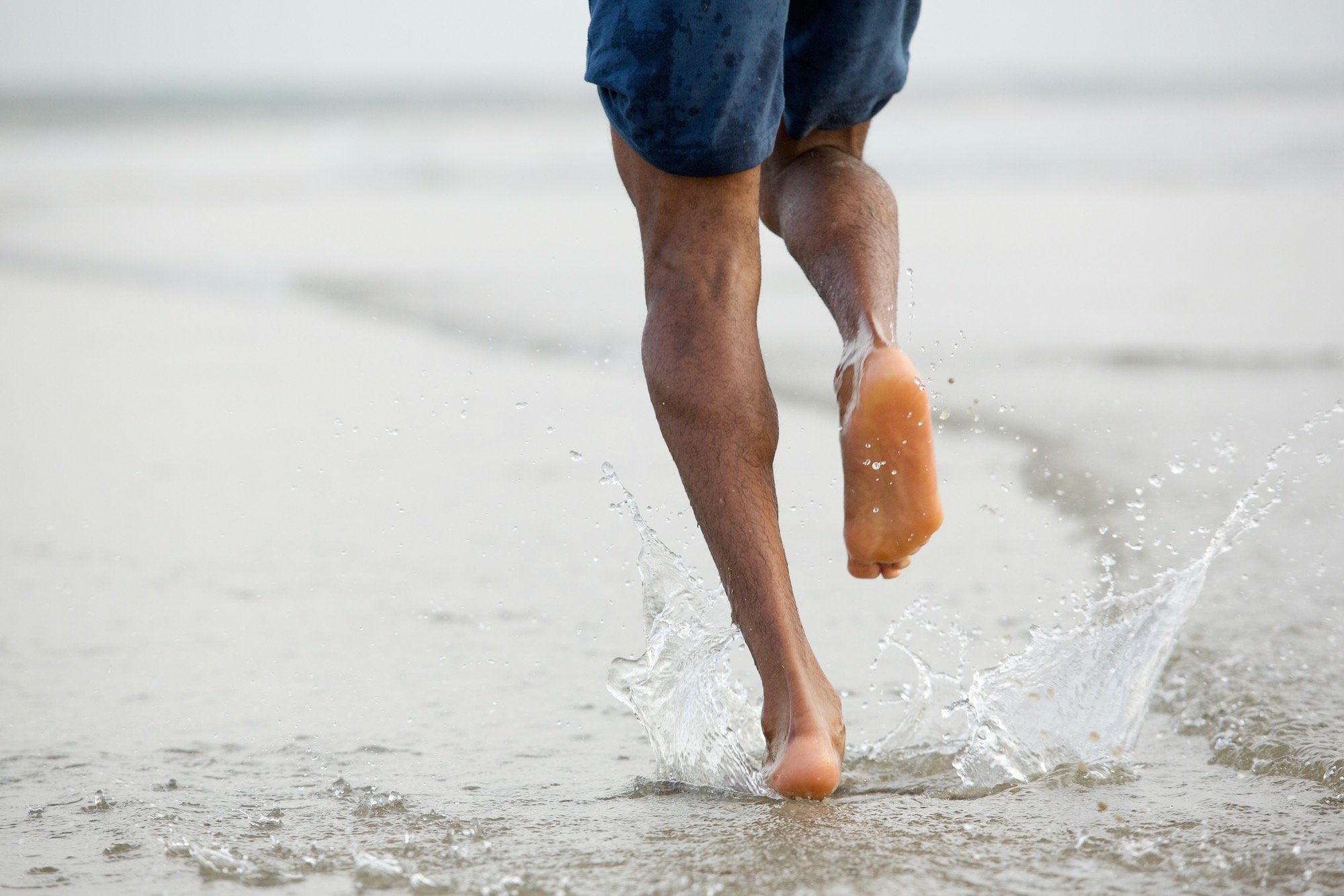 Man Running on Beach to Relieve Foot Pain