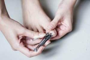 Young Woman Clipping Ingrown Toenail