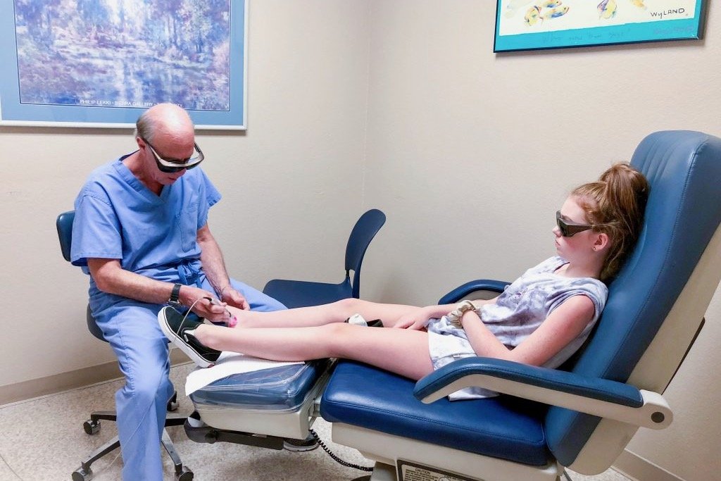 Young Pediatric Patient Sitting Through Laser Therapy Treatment for the Foot and Ankle