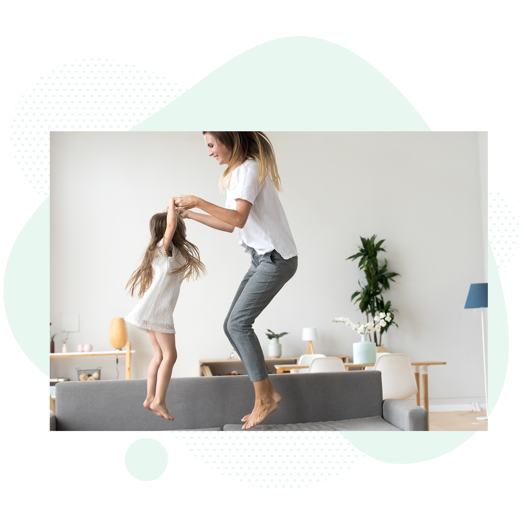 Mom and daughter jumping on a couch