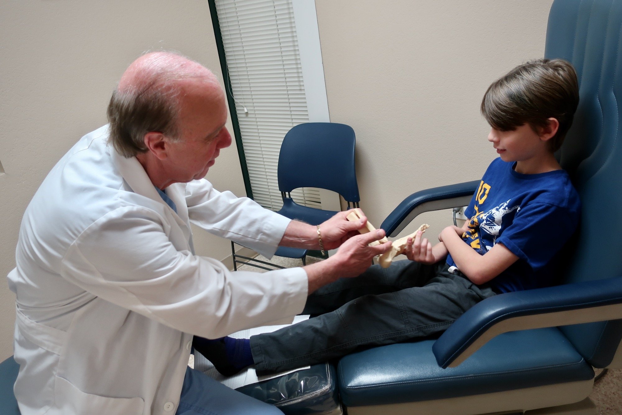 young-boy-mom-at-scottsdale-podiatrist-for-foot-checkup_arizona-foot-doctors-359 Young Patient Describing Foot Pain and Discomfort with Foot Model